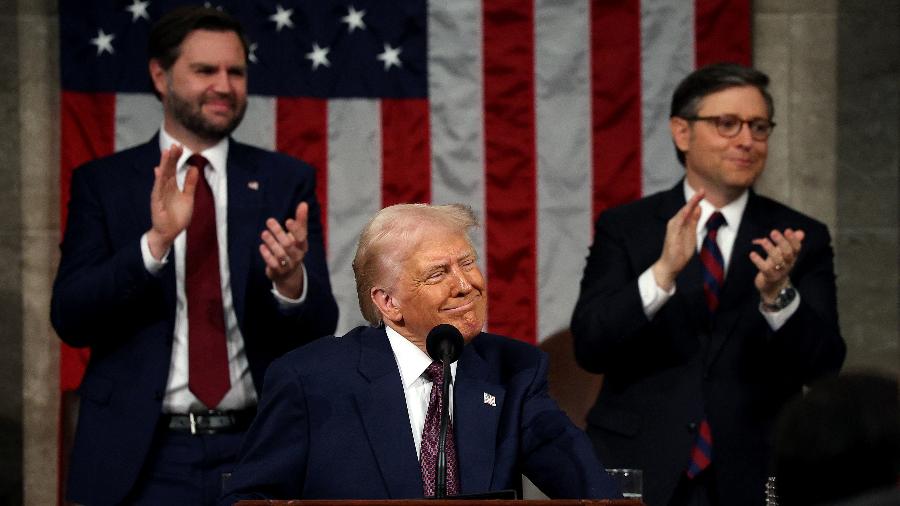 Presidente Donald Trump é aplaudido pelo vice-presidente JD Vance (esq.) e pelo congressista republicano Mike Johnson ao discursar para os congressistas no Capitólio, em março de 2025